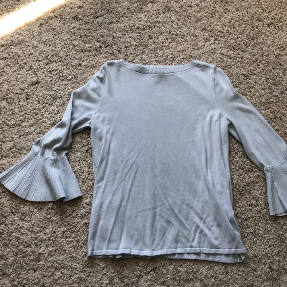 Powdery blue sweater with flowing detailed sleeves.